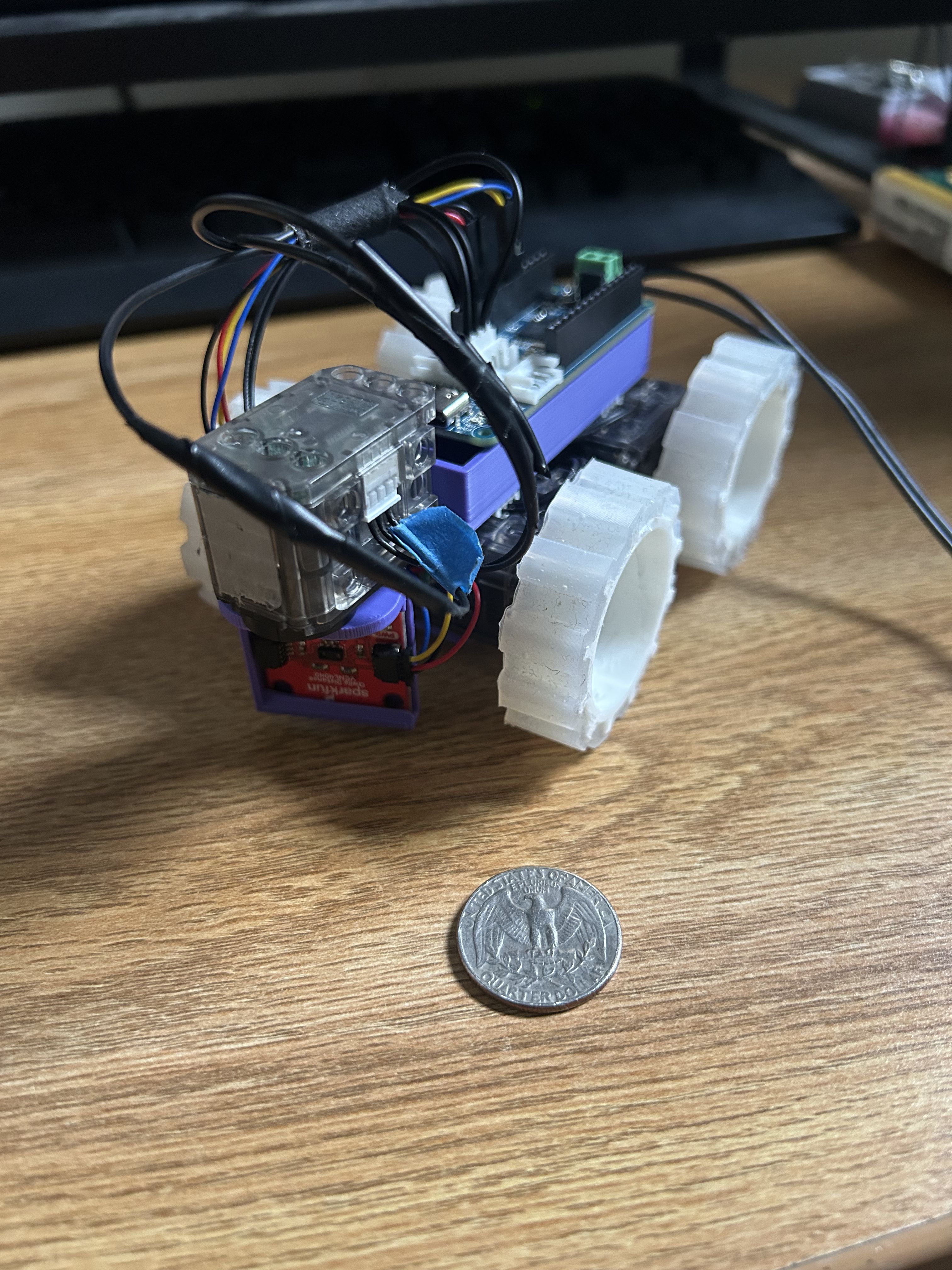 mini 4 wheeled bot next to a quarter